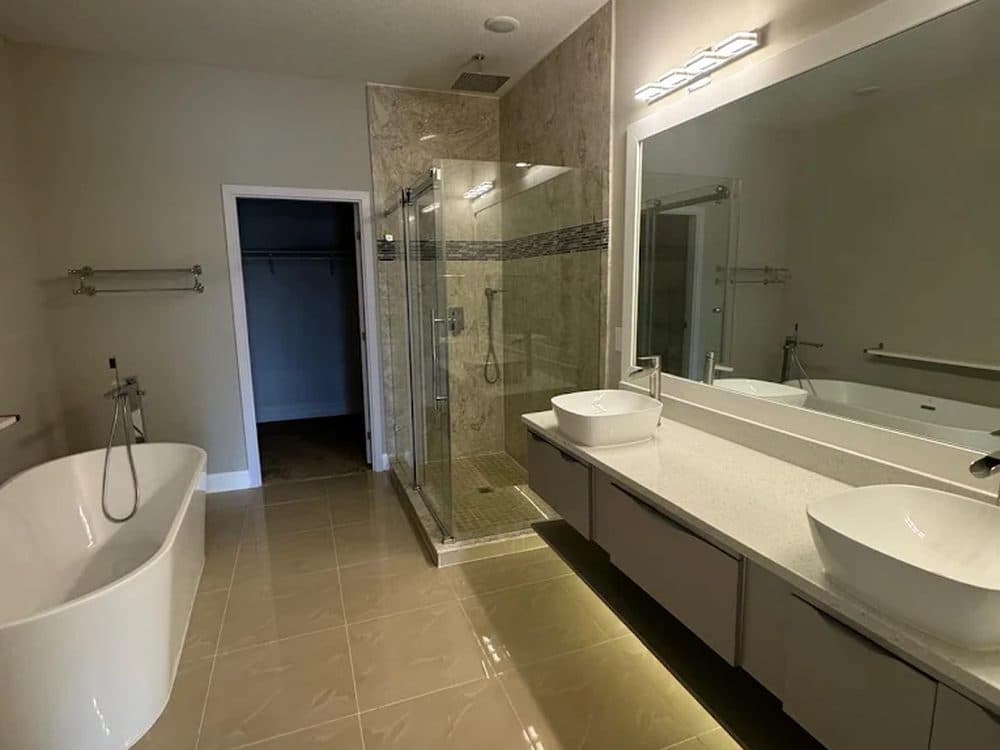 Interior repaint — a bright bathroom with a freestanding tub and crisp white walls and trim.