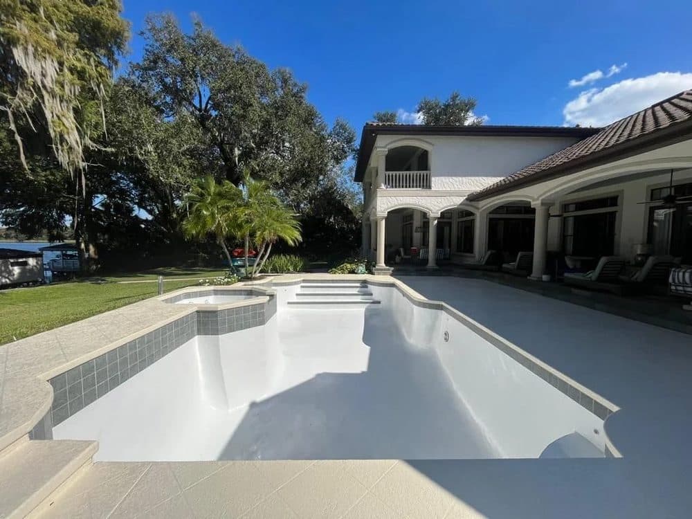 Exterior repaint — rear elevation of a two-story home overlooking a screened pool.
